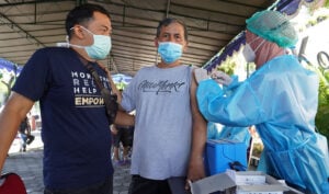 Nakes tengah menyuntikan vaksin dalam sebuah kegiatan organisasi masyarakat di Yogyakarta. Foto oleh Agung P/Mojok.co
