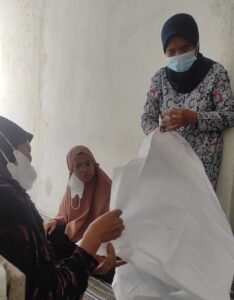 Modin perempuan menyiapkan kain kafan mojok.co