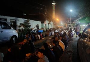 Para jemaah bersila dengan alas sajadah sekitar 100 meter dari masjid karena halaman sudah penuh. (Prima Ardiansah:Mojok.co)