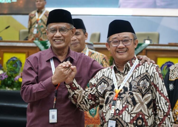 Haedar Nashir dan Abdul Mu'ti berfoto bersama usai terpilih menjadi Ketum dan Sekum PP Muhammadiyah. (Hammam Izzuddin/Mojok.co)