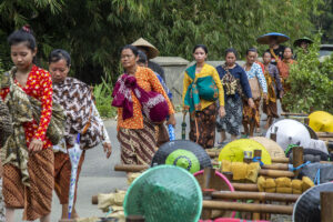 Dili (kebaya kuning) dan Marni di belakangnya, dalam perjalanan menuju Desa Pekuncen. MOJOK.CO