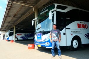 Putra di depan dua armada Bus Bimo yang ada di garasi. MOJOK.CO