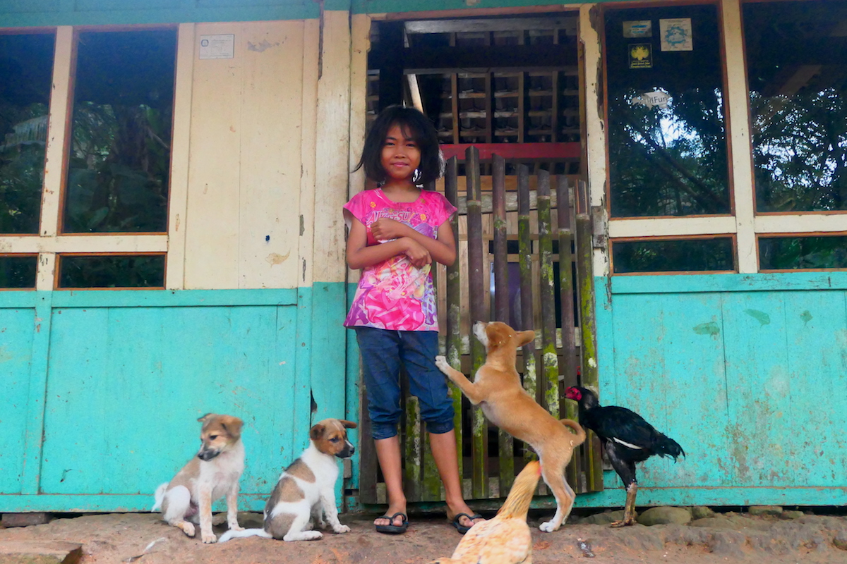 Dewi Septiani, bermain dengan tiga anak anjing yang jadi penjaga rumahnya. MOJOK.CO