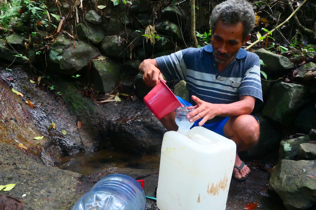 Sumiran mengambil air dari sungai yang berjarak seratusan meter dari rumahnya. MOJOK.CO