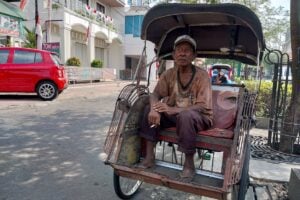 Ngatiyo, tukang becak di Jalan Margo Utomo saat diambil gambarnya, Jumat (11/8/2023). Sudah biasa ia berhari-hari ia tidak mendapatkan penumpang.