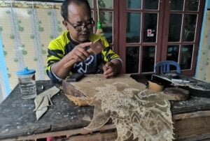 Nardi Wayang tengah menatah wayang pesanan dari pelanggannya MOJOK.CO