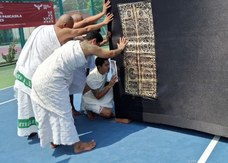 Para napi memegang replika kabah. MOJOK.CO