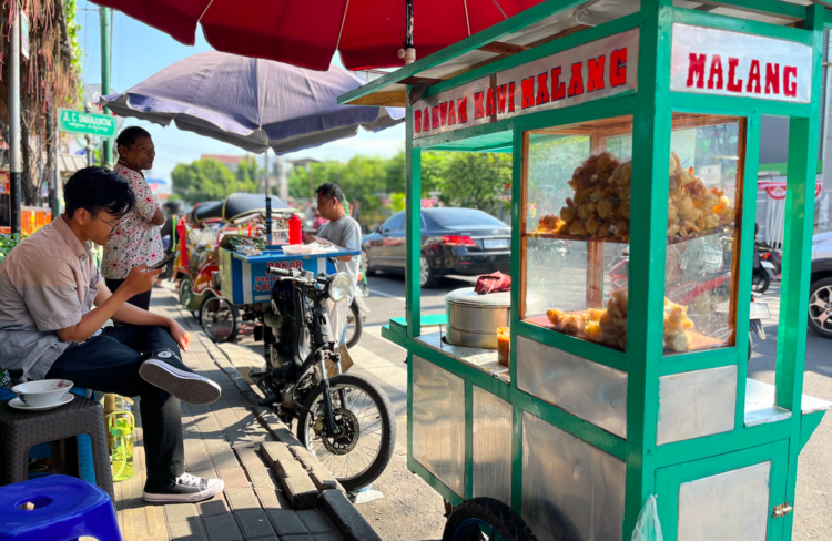 Suroto membantu melayani lapak pedagang lain MOJOK.CO