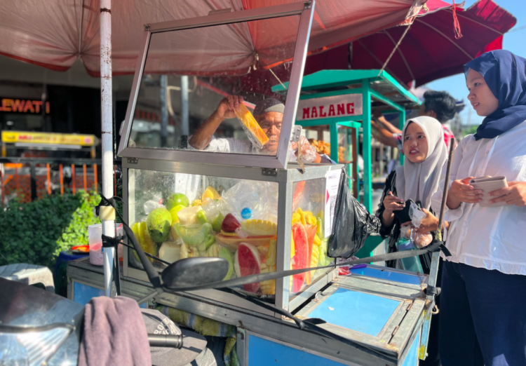 Suroto, pedagang rujak lotis di Jogja saat melayani pembeli MOJOK.CO