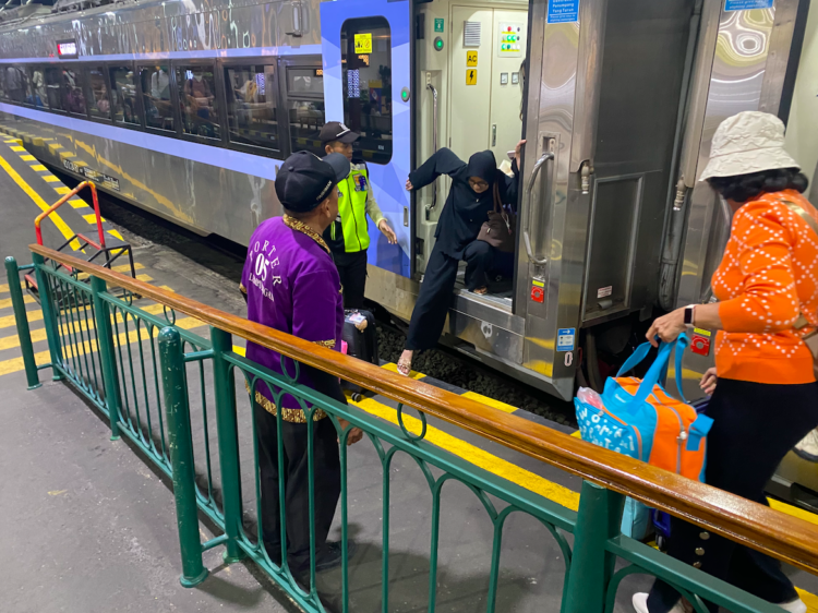 Porter menanti penumpang turun dari kereta api MOJOK.CO