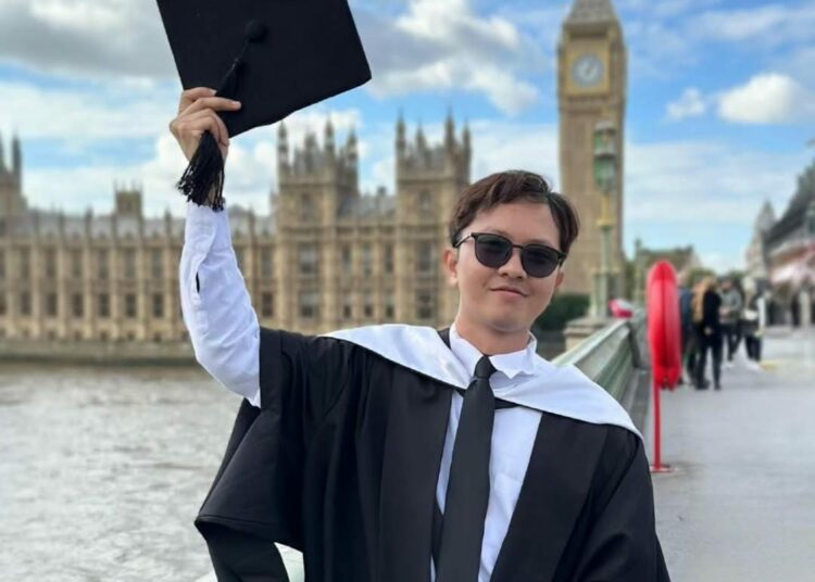 Rifqi Irvansyah mengangkat toga. MOJOK.CO