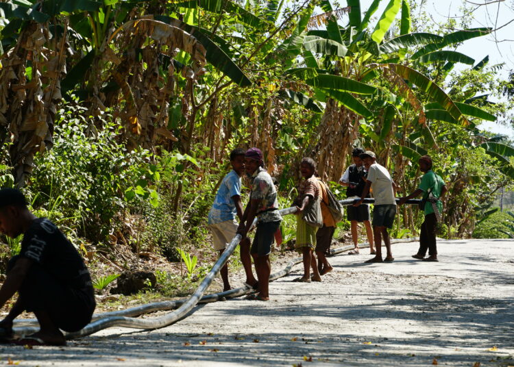 Warga Desa Nifukani, Nusa Tenggara Timur (NTT) gotong royong salurkan air melalui pipa dari Alfamart MOJOK.CO
