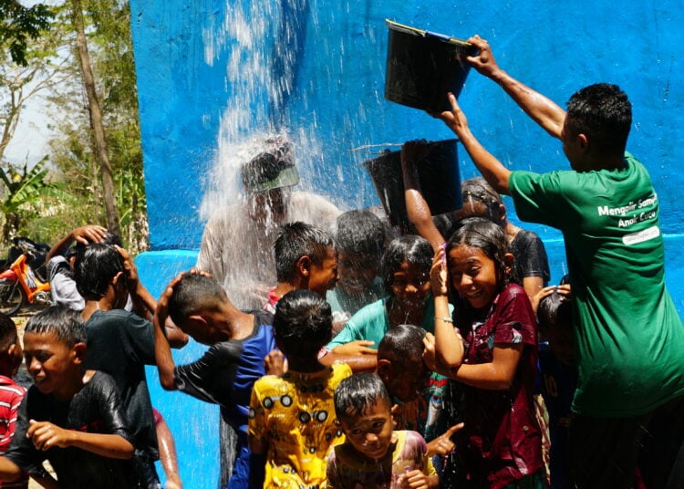Anak-anak menikmati limpahan air bersih MOJOK.CO