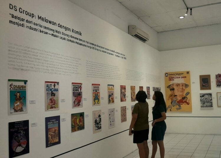 Pengunjung melihat pameran. MOJOK.CO