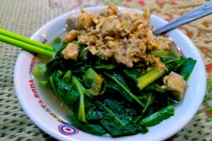 Seporsi mie ayam bakso Pak Sunar dengan toping sawi dan daging ayam MOJOK.CO