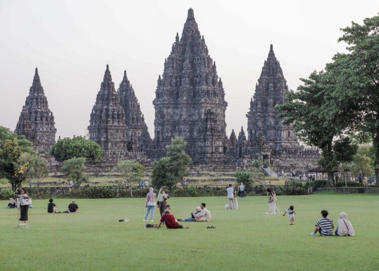 pengunjung piknik di depan candi. MOJOK.CO