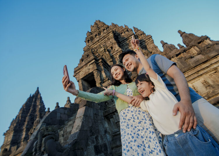 Keluarga foto di depan candi. MOJOK.CO