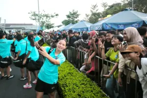 Neila (baju hijau) bergaya ketika salah satu pemain Thailand selfie dengan mereka. Banyak fans remaja asal Indonesia yang meminta tanda tangan maupun sekadar selfie dengan pemain asing di Srikandi Merdeka Cup 2026 yang berlangsung di Supersoccer Arena, Kudus. MOJOK.CO