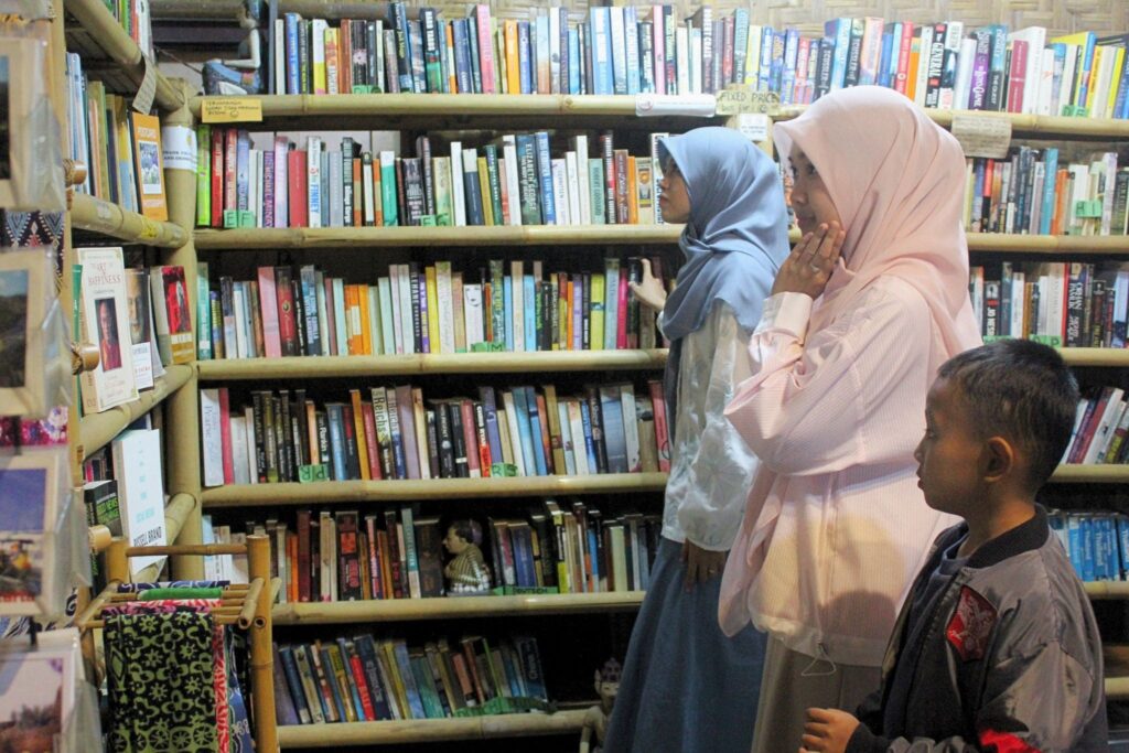Pengunjung sedang melihat koleksi buku The Lucky Boomerang. MOJOK.CO
