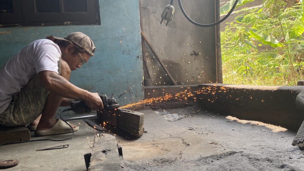 Seorang pandai besi sedang bekerja. MOJOK.CO